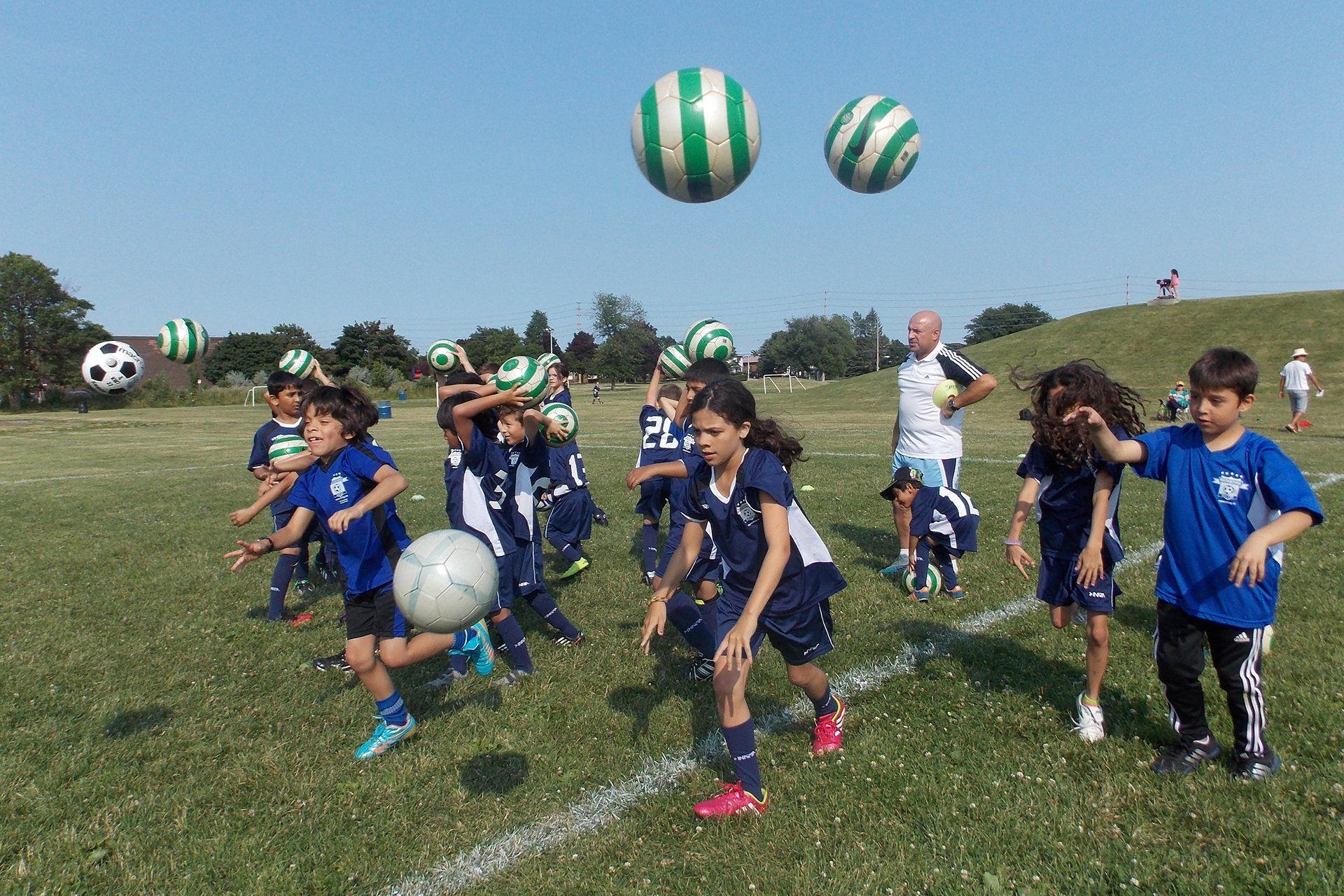 A group of children are playing soccer on a field.