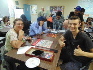 A group of people are sitting around a table playing a board game.
