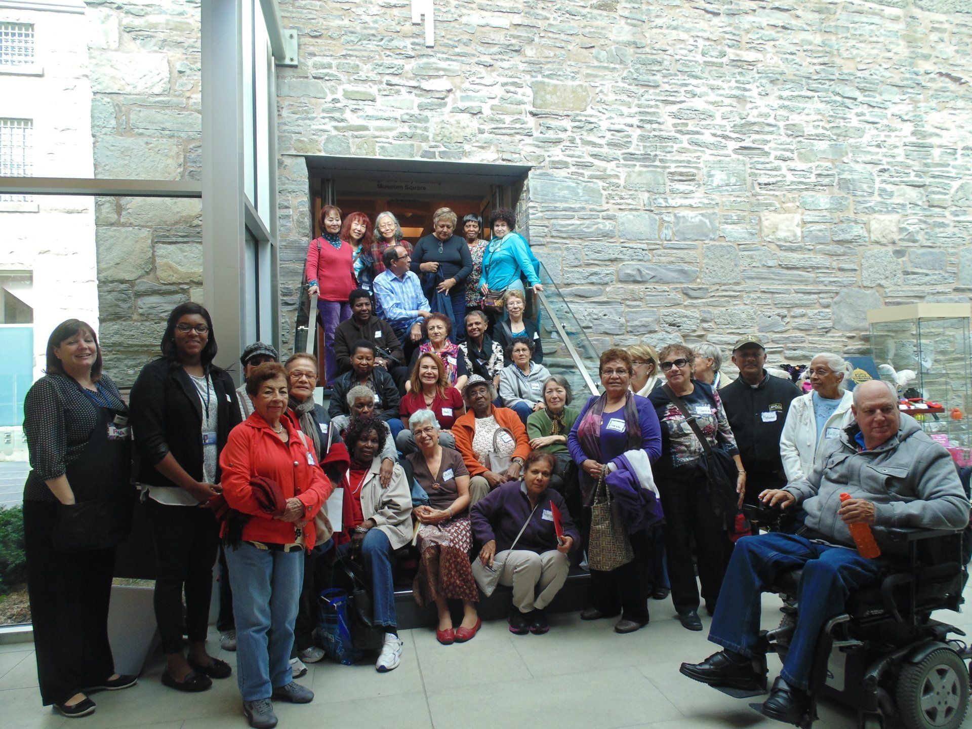 A group of people are posing for a picture in front of a stone building