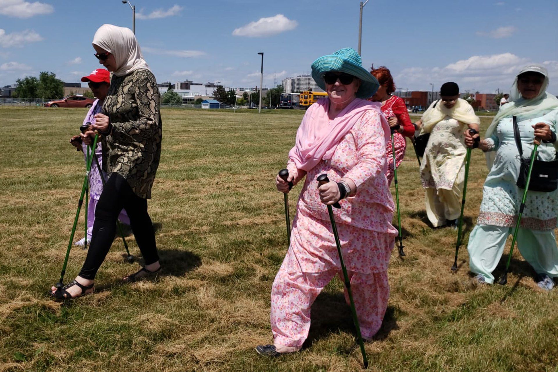 A group of women are walking in a field with walking poles