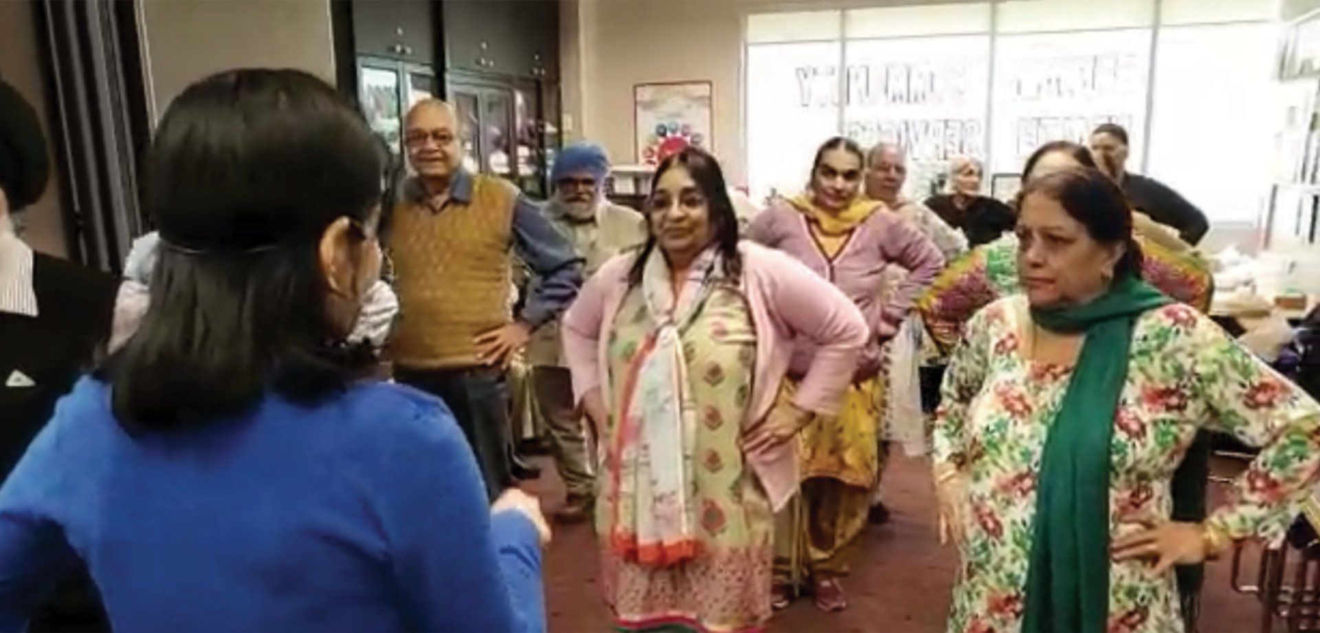 A group of women are standing in a room with their hands on their hips.