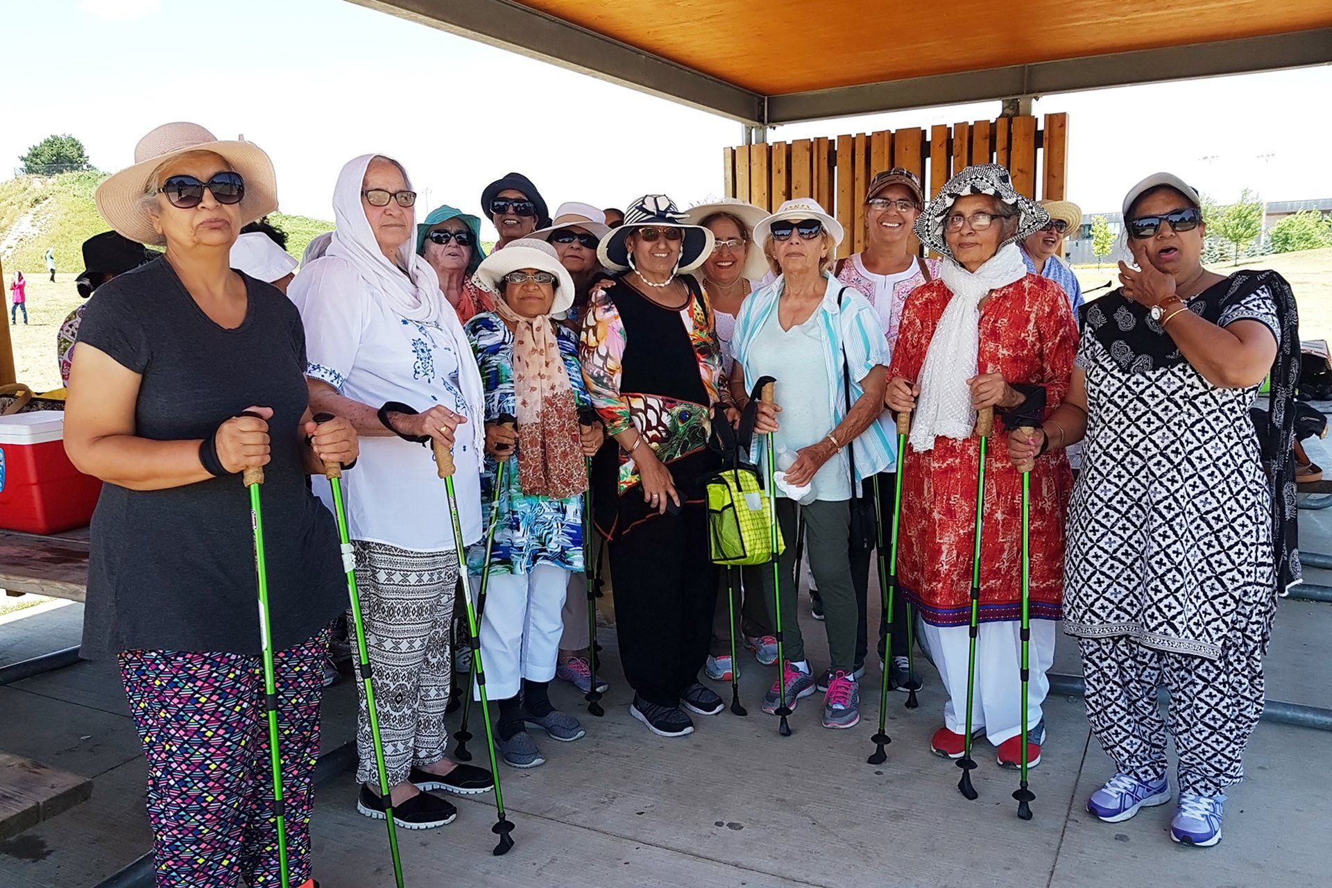A group of women standing next to each other holding walking poles.