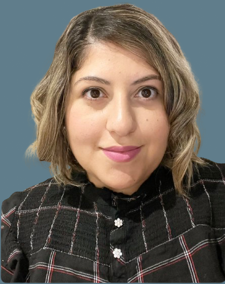 A woman wearing a plaid shirt is smiling for the camera