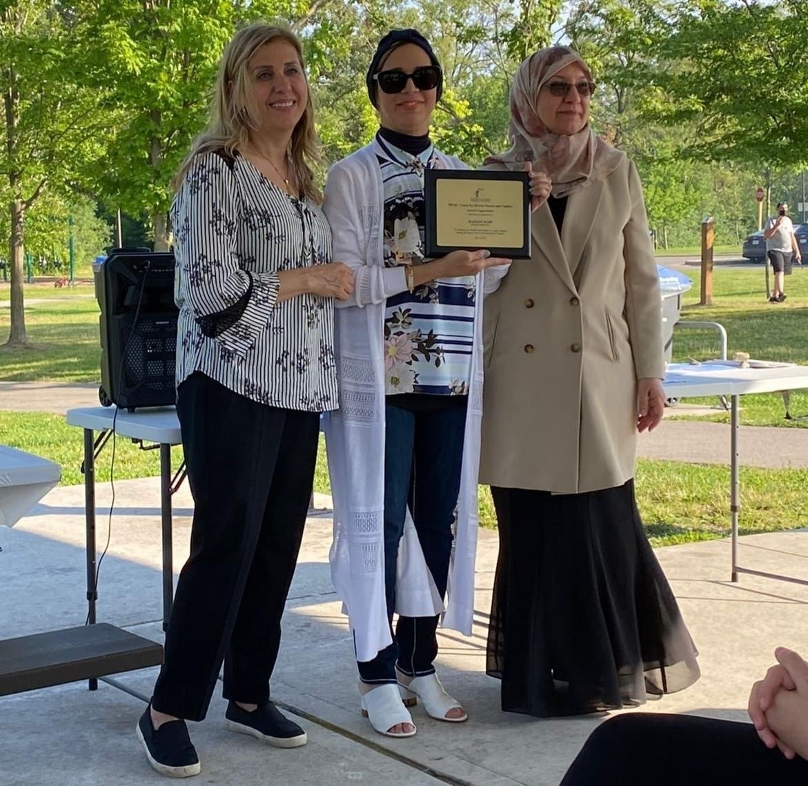 Three women standing next to each other holding a certificate