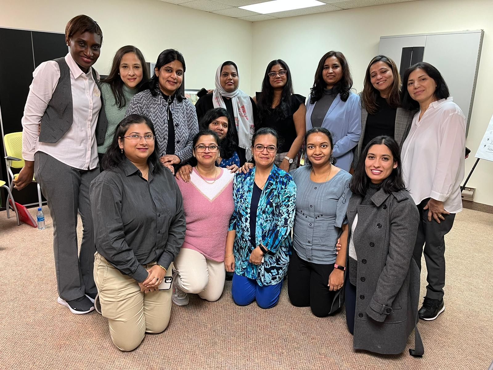 A group of women are posing for a picture in a room.