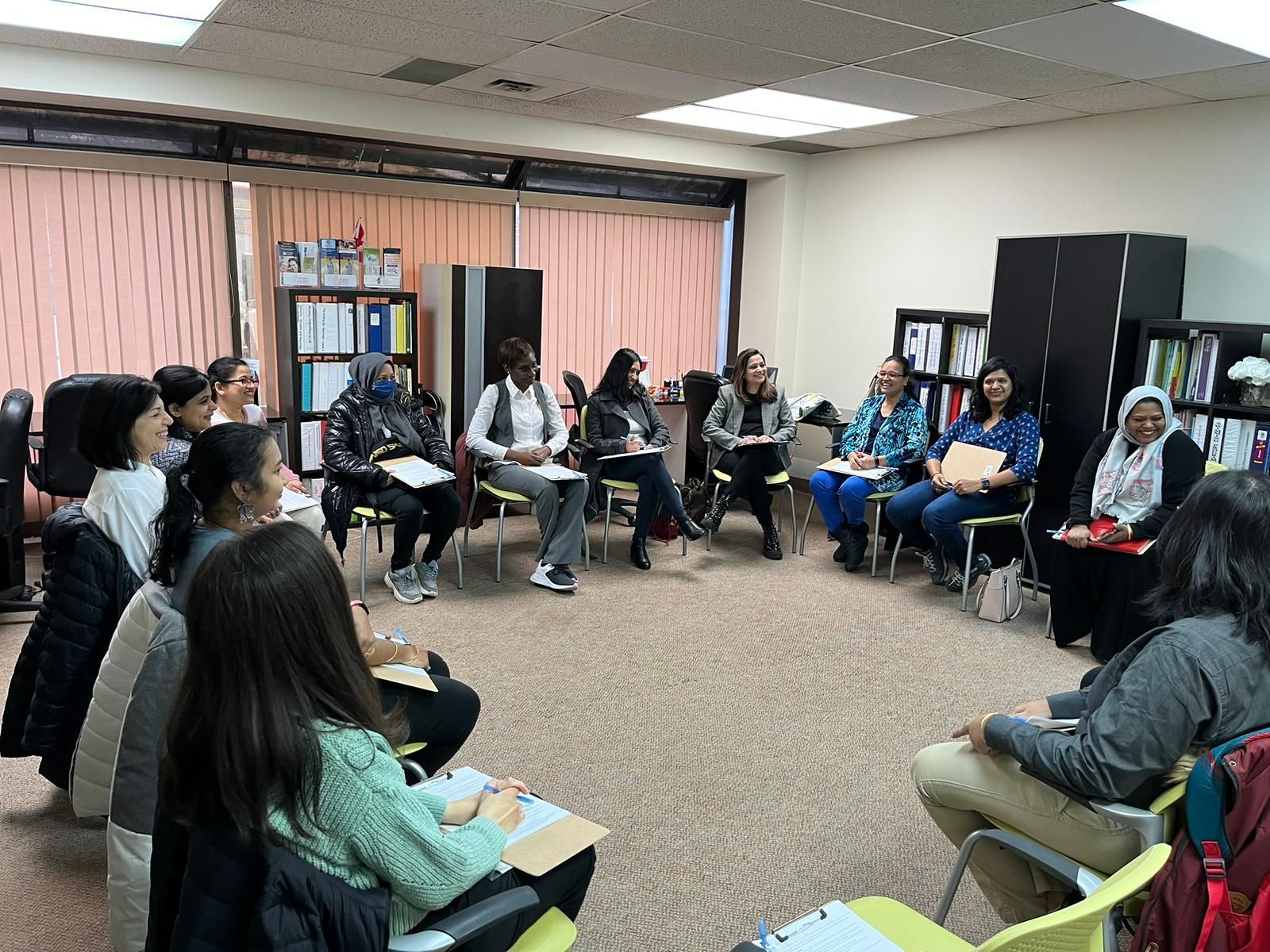 A group of people are sitting in a circle in a room.