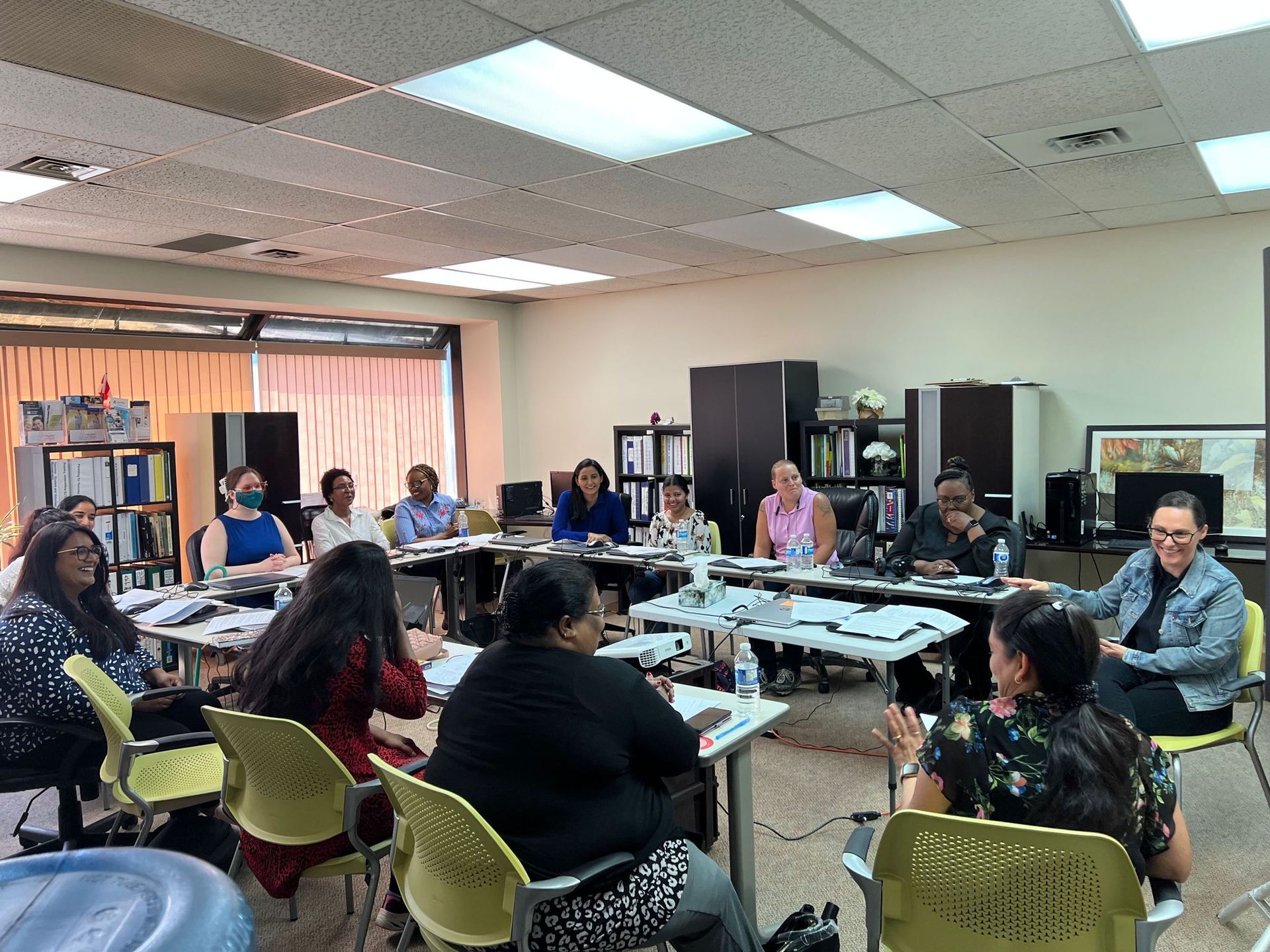 A group of people are sitting around a table in a room.