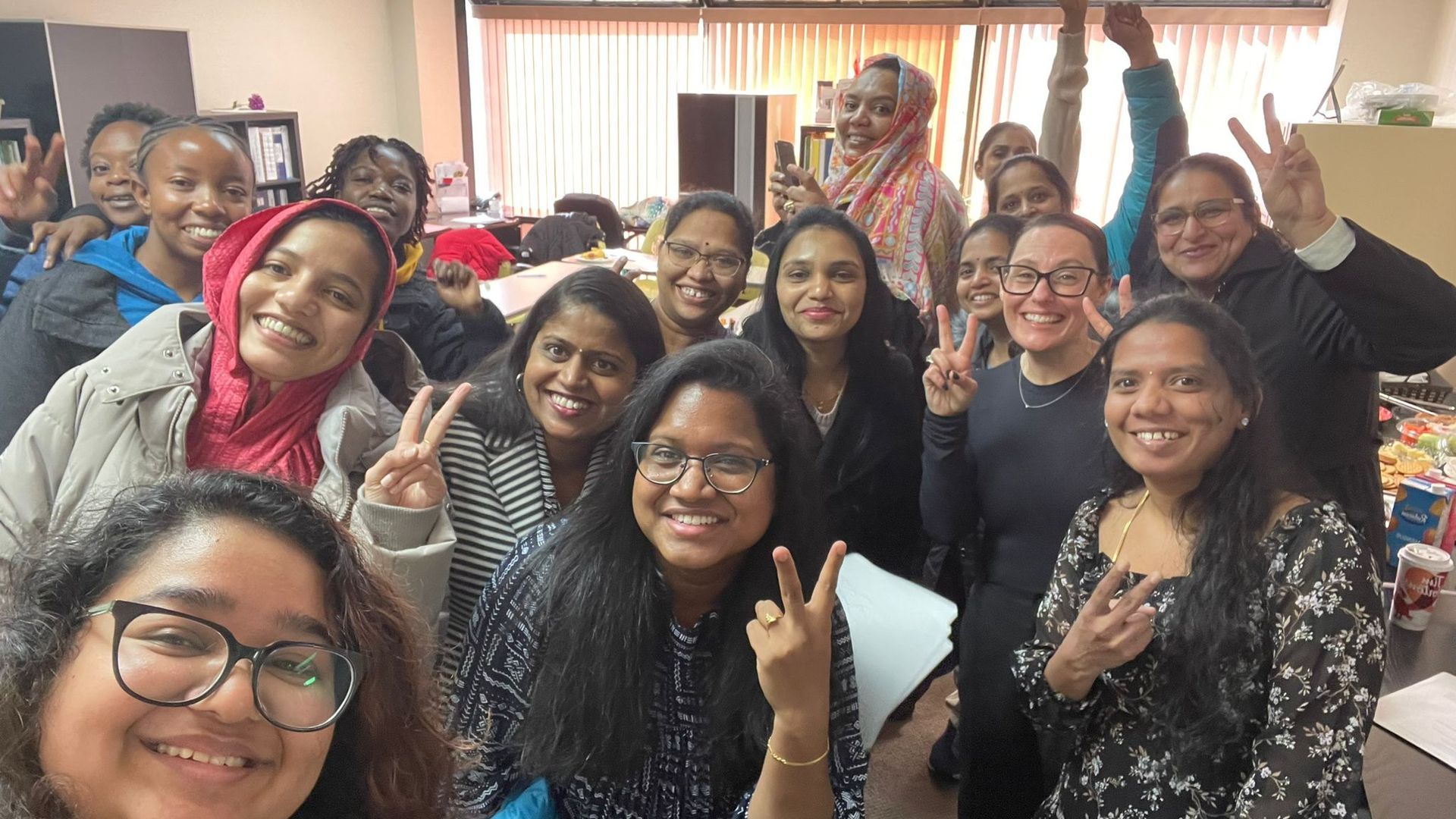 A group of people are posing for a picture in a room.