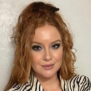 A close up of a woman 's face wearing a zebra print shirt.