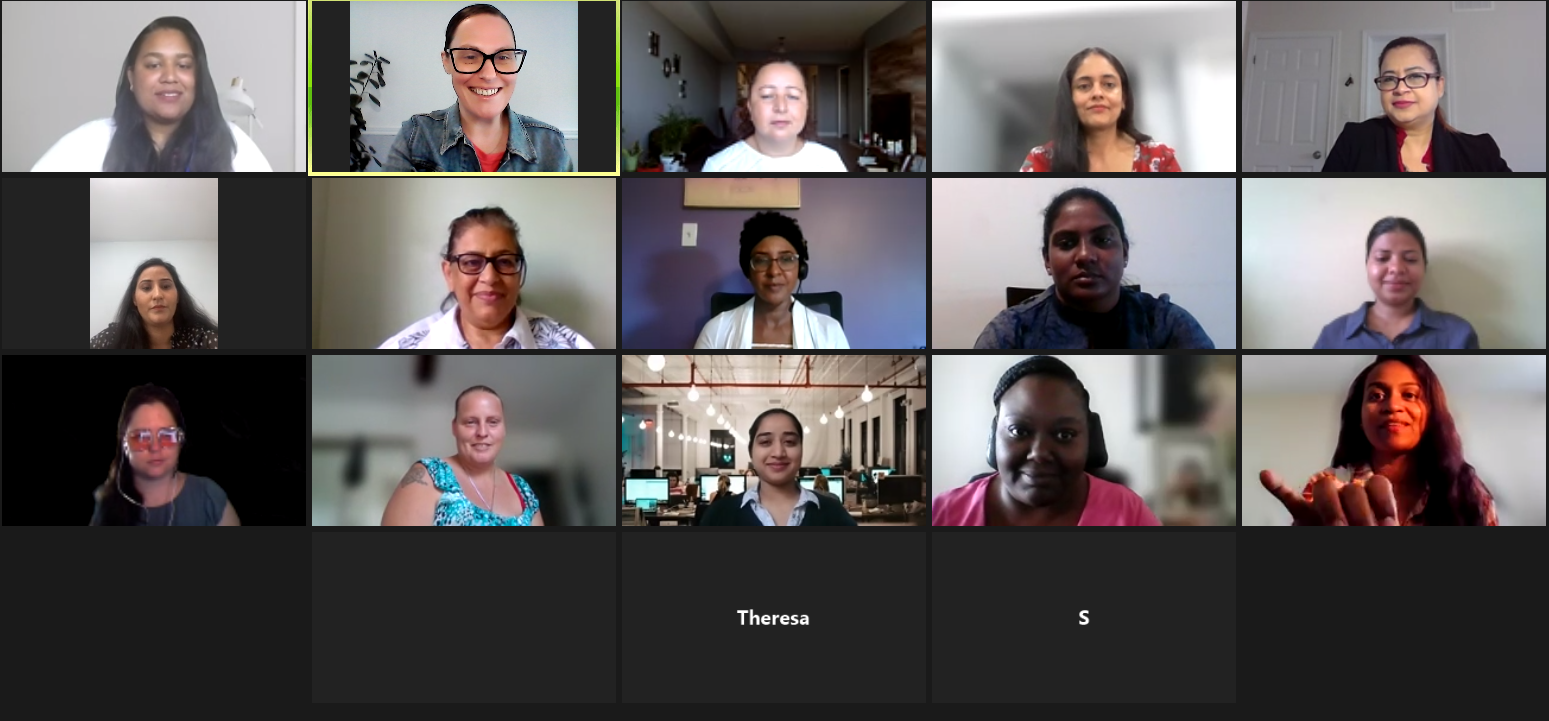 A group of people are sitting in front of a computer screen.