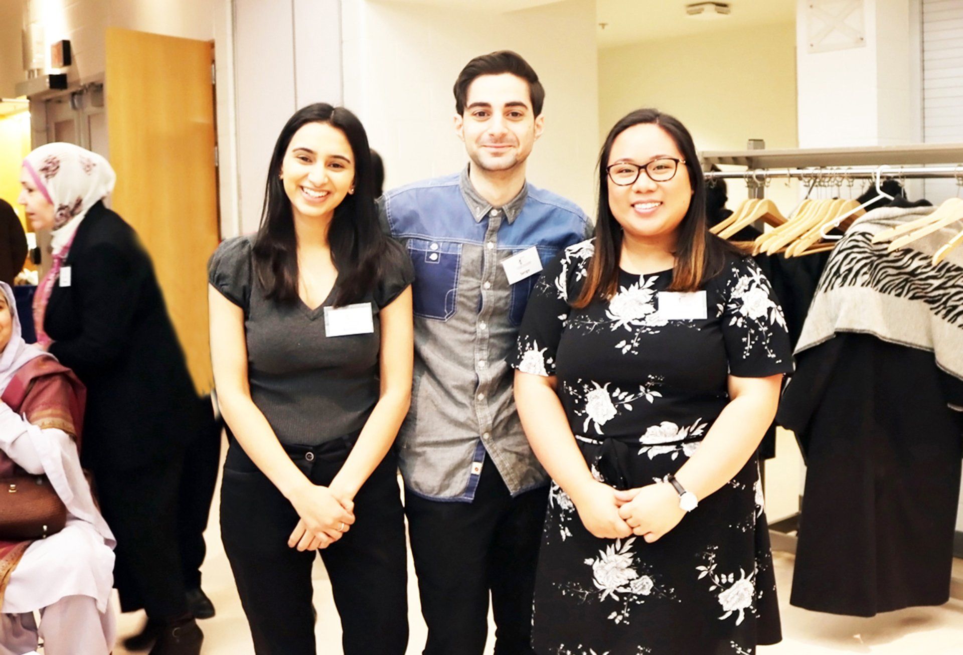 A man and two women are posing for a picture in a store.