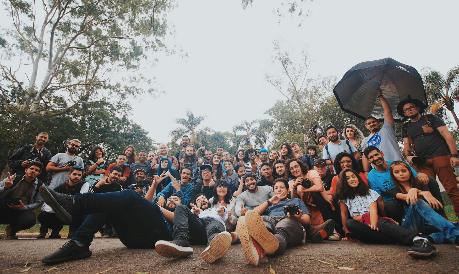 A large group of people are posing for a picture in a park.