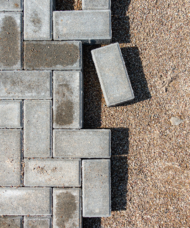 a man in orange overalls is holding a pole in front of a house