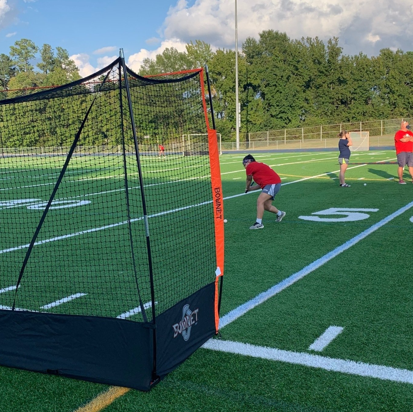 A man in a red shirt is running on a football field