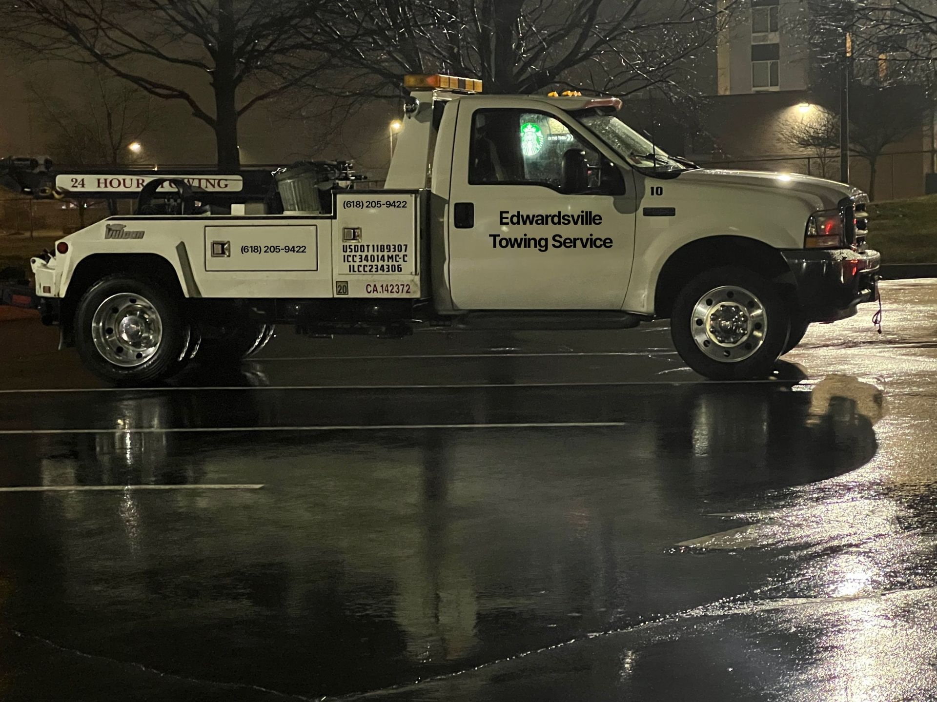 a white edwardsville towing service truck is parked in a parking lot