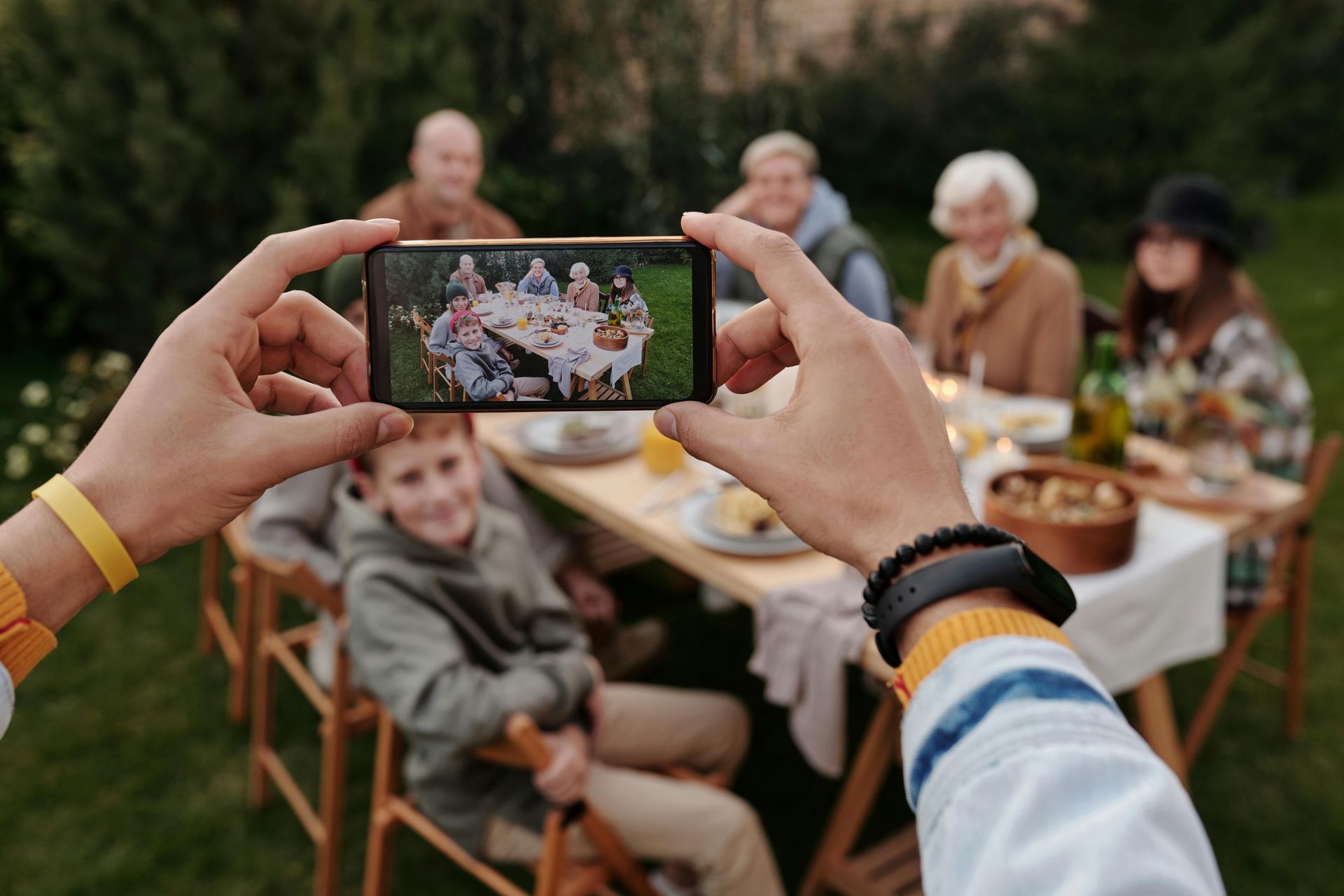 A person is taking a picture of a family sitting at a table.