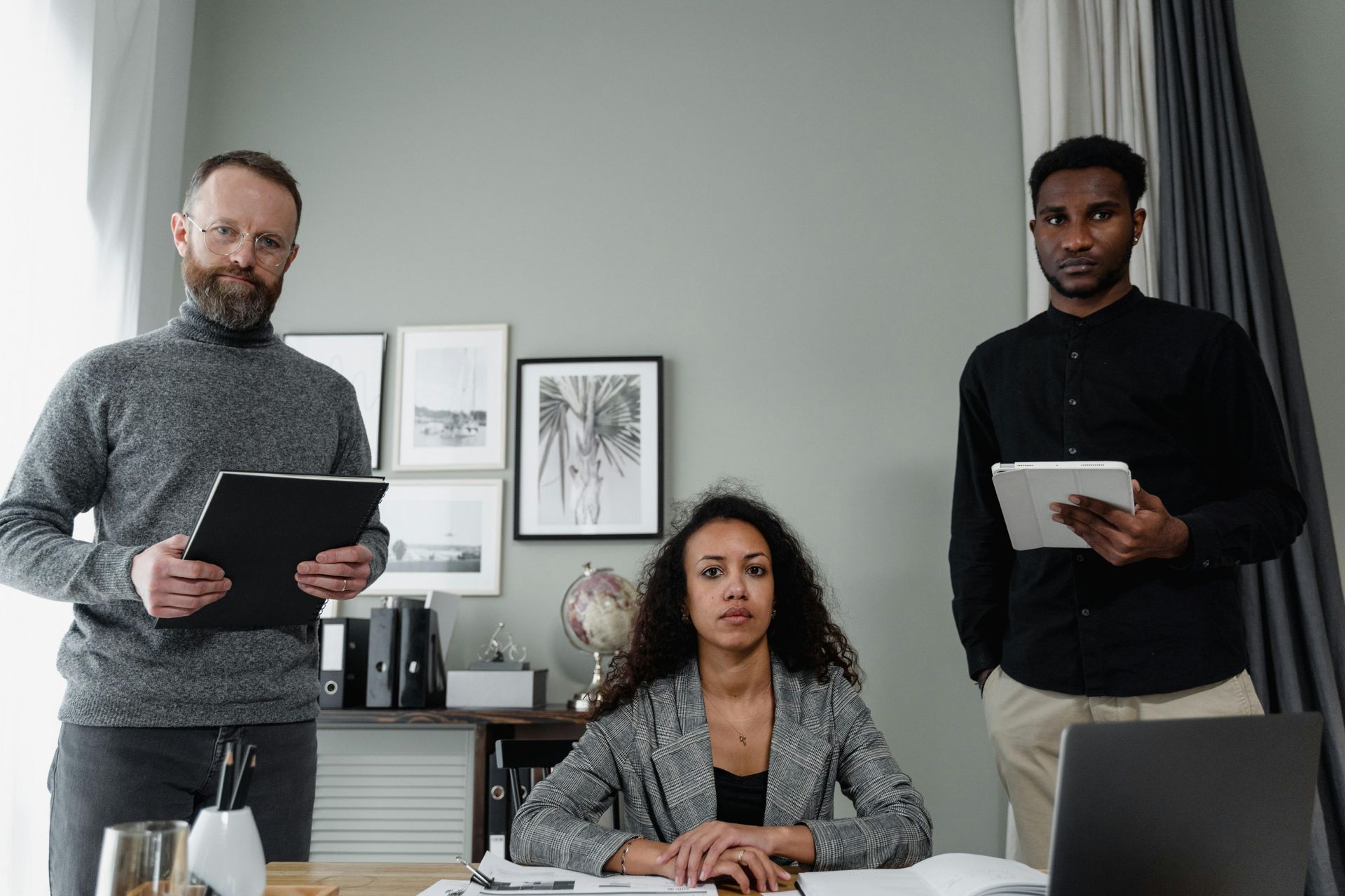 A group of people are standing around a table in an office.