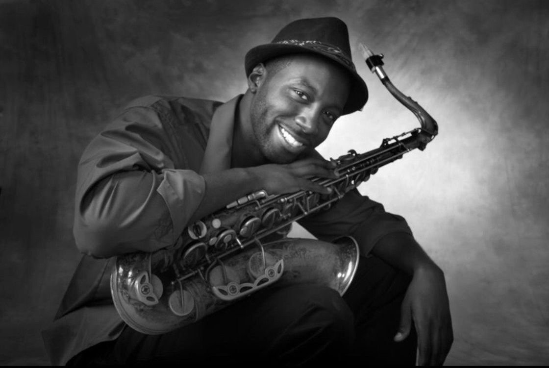 A black and white photo of a man holding a saxophone