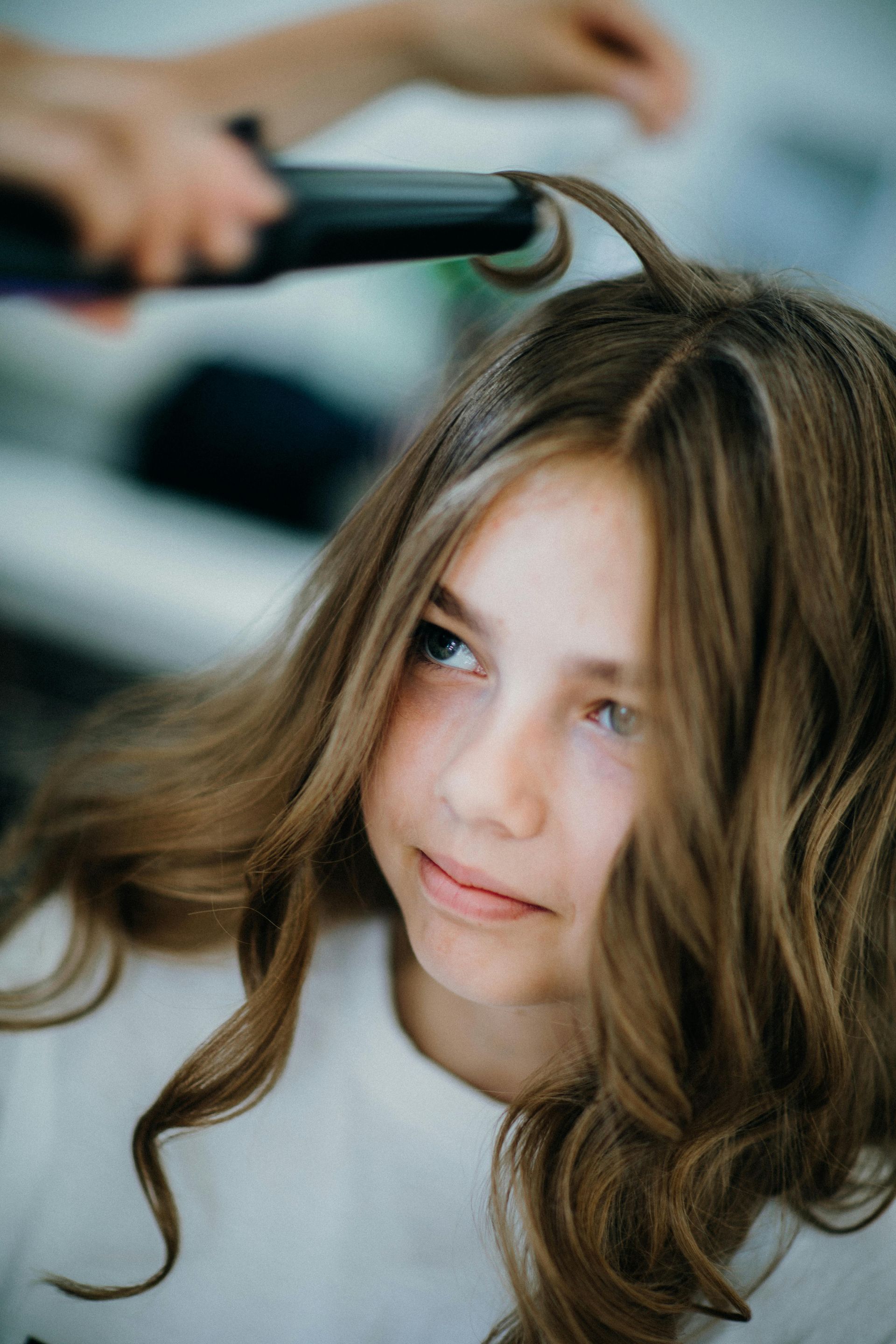 A person receiving a facial treatment. A esthetician applies a mask to the client's face.
