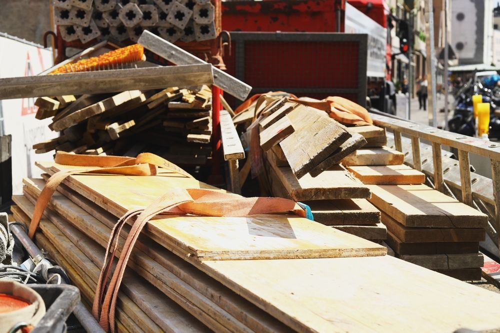 Lumber and supplies stacked on a truck bed; strapped for transport.