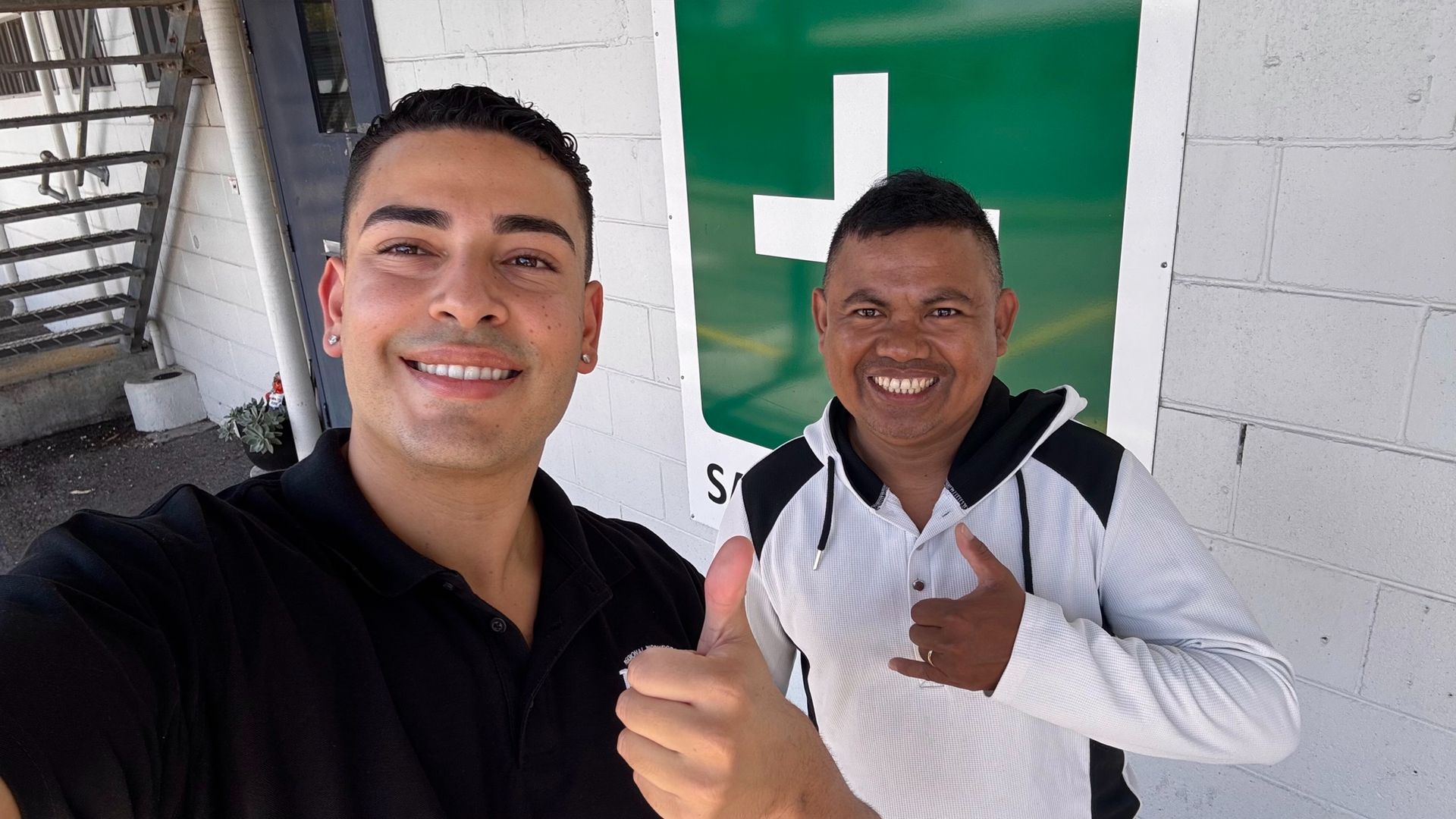 Four people stand in front of a client truck, including two workers in high-vis uniforms, a client and a recruitment manager, representing skilled trades recruitment.