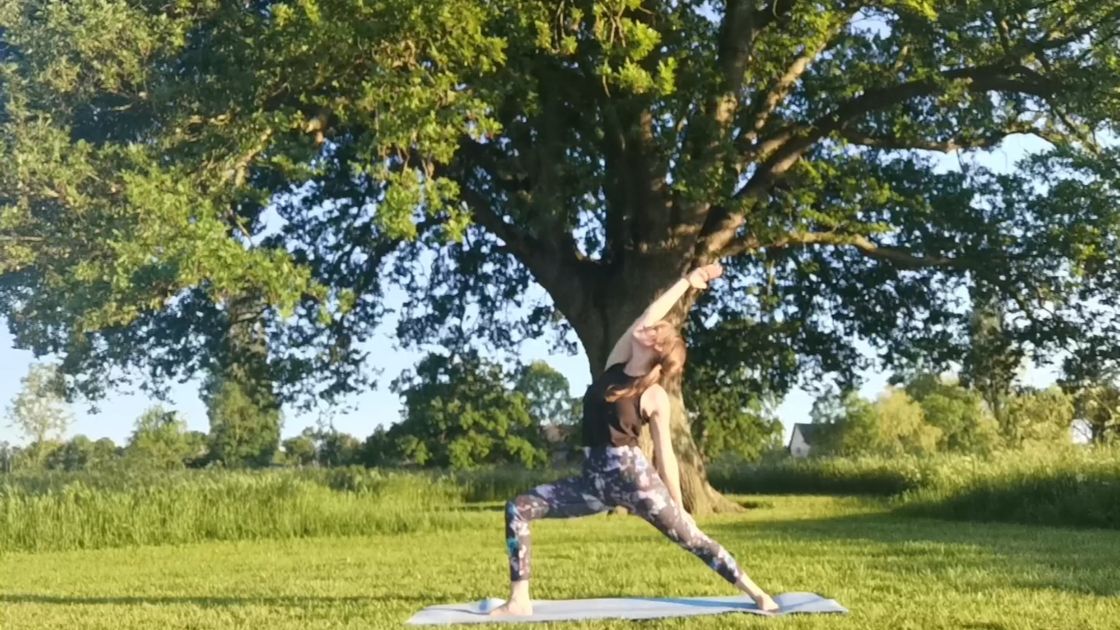 Woman doing a yoga pose under an oak tree