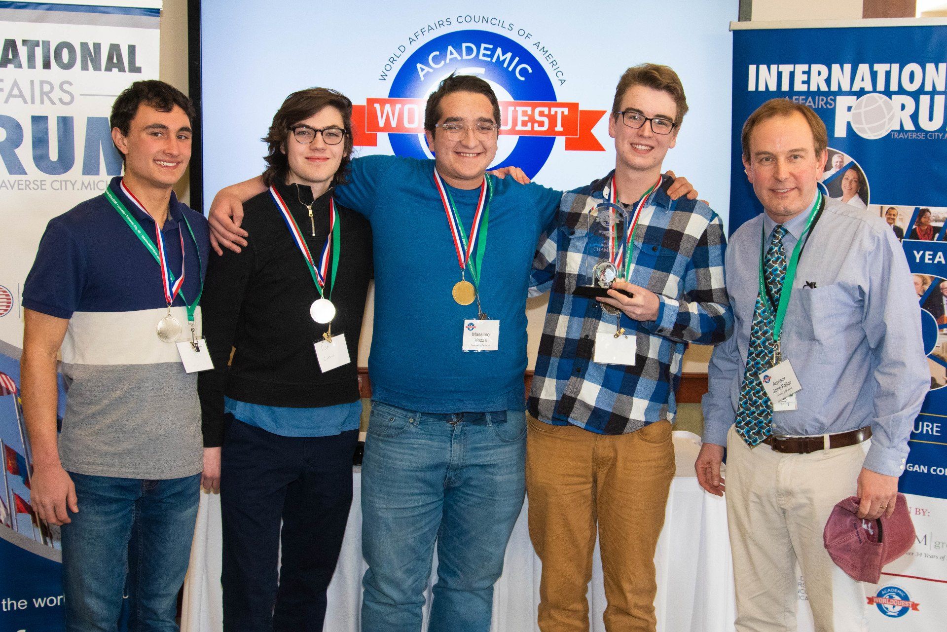 A group of young men are posing for a picture in front of a sign that says international forum