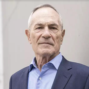 A man in a suit and tie is smiling for the camera.