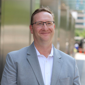 A man in a suit and tie is smiling for the camera.