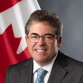A man in a suit and tie is smiling for the camera.