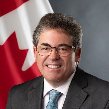 A man in a suit and tie is smiling for the camera.
