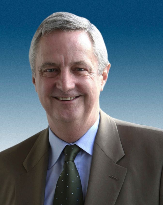A man in a suit and tie is smiling for the camera.