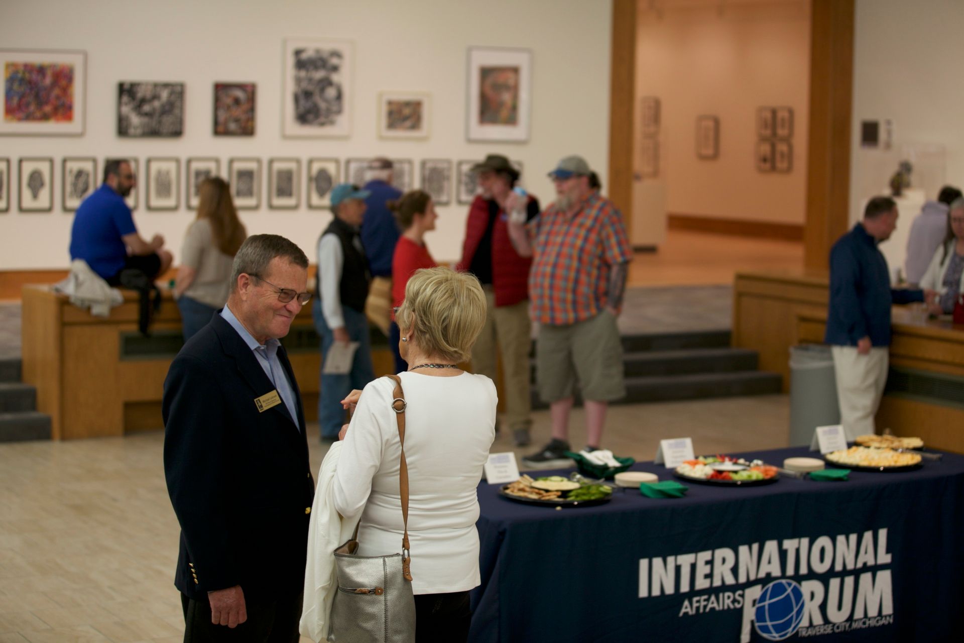 A group of people standing around a table that says international forum