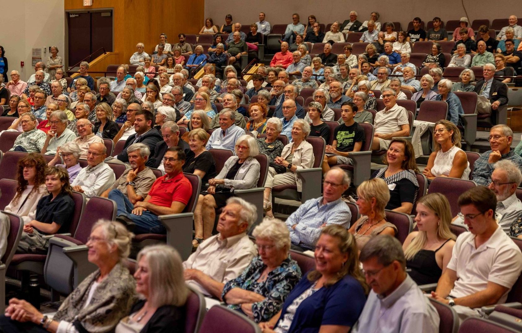 A large group of people are sitting in a lecture hall