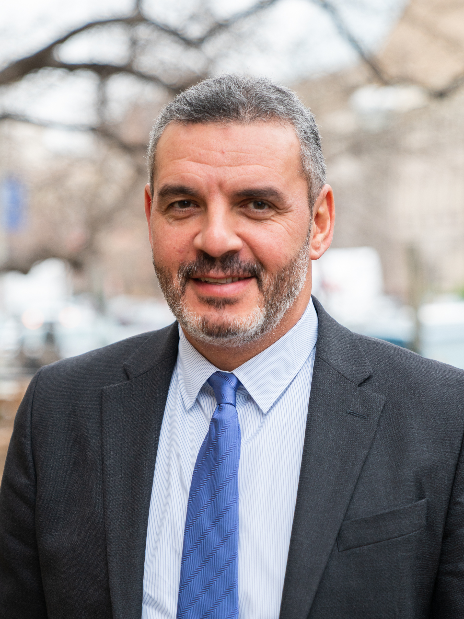 A man in a suit and tie is smiling for the camera.