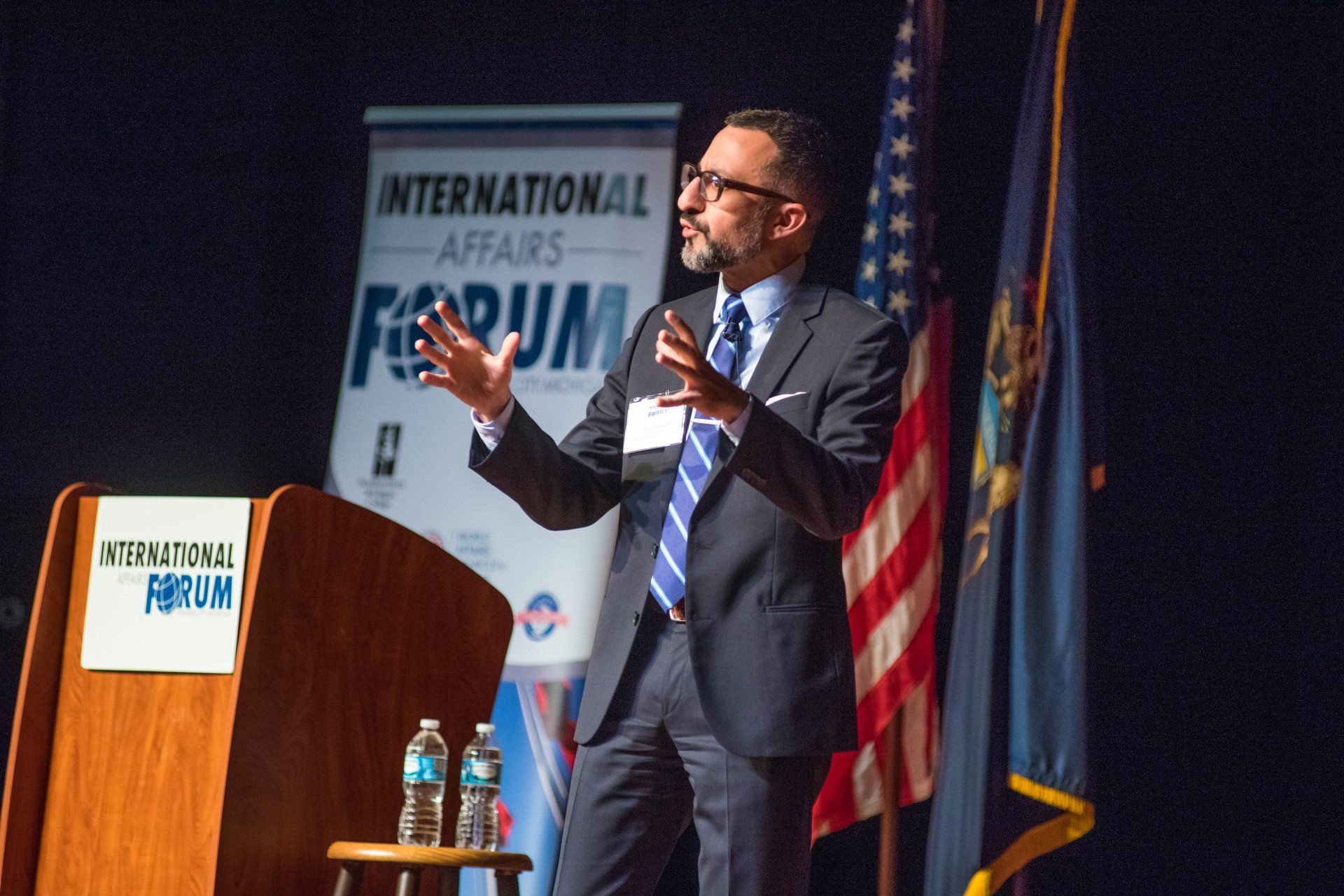 A man in a suit and tie is giving a speech at the international forum