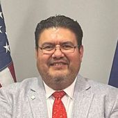 A man in a suit and tie is smiling for the camera.