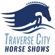 Logo of Traverse City Horse Shows featuring a blue horse jumping over water, with text: Traverse City Horse Shows.