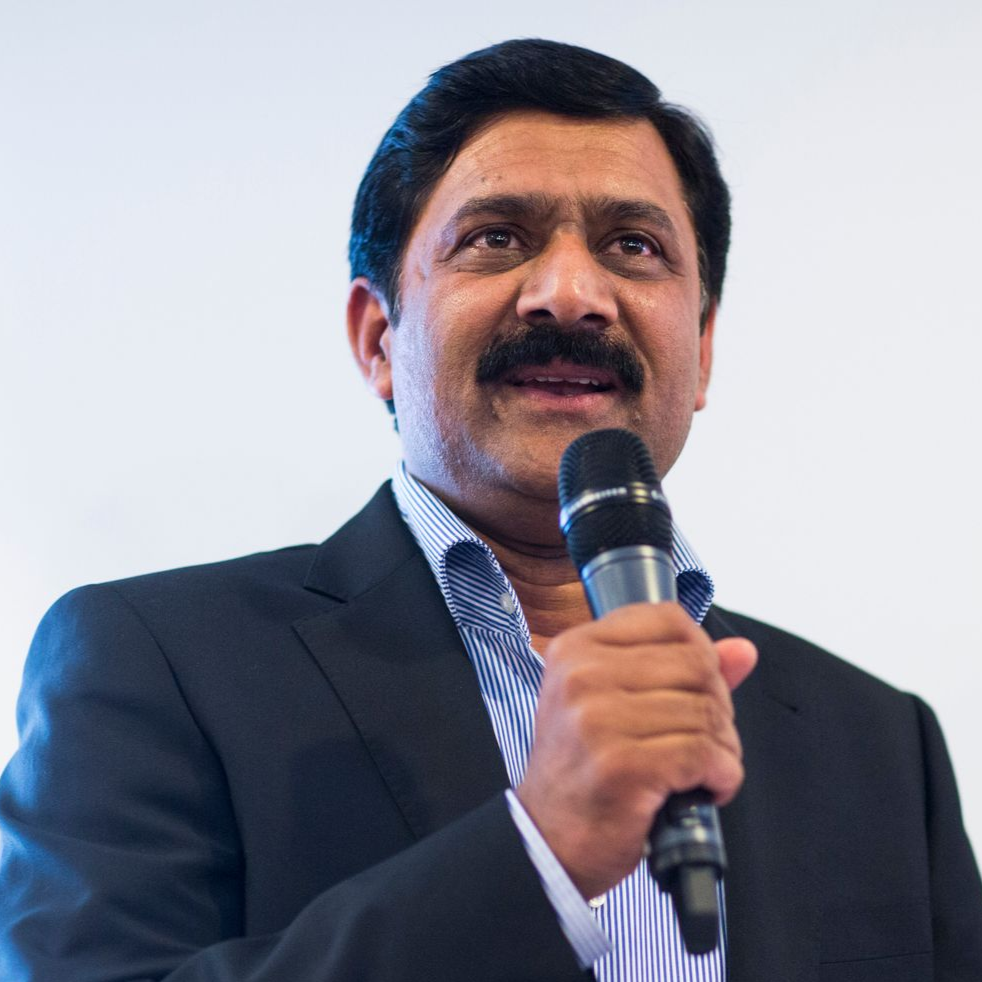 A man in a suit and tie is smiling for the camera.