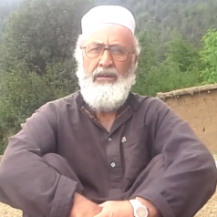 A man with a beard wearing glasses and a white hat