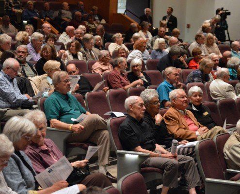 A large group of people are sitting in a lecture hall