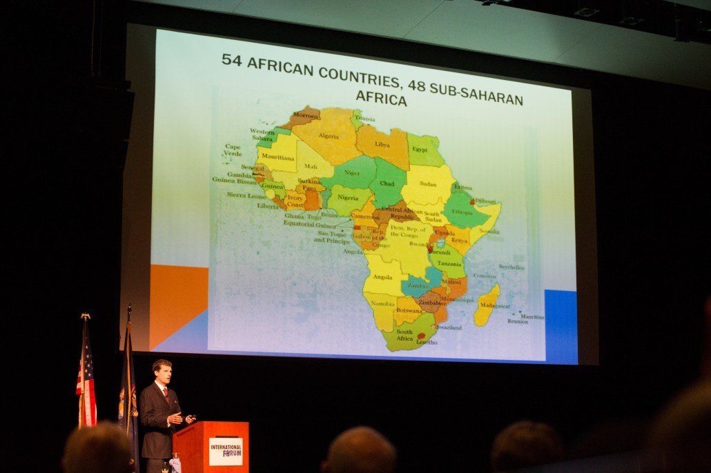 A man giving a presentation with a map of africa on the screen