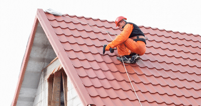 A man is working on the roof of a house.