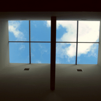 Looking up at the sky through a skylight in a building.