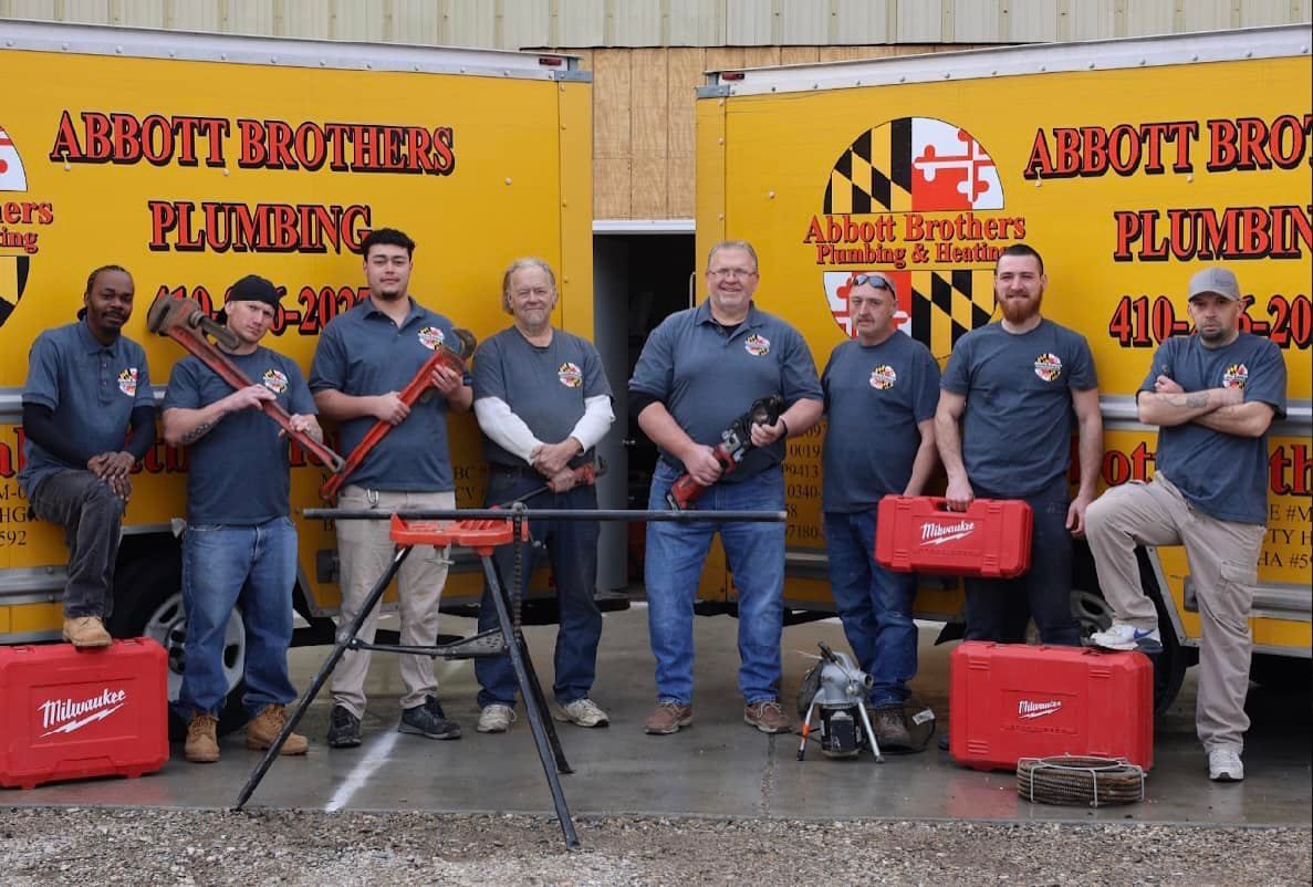 A group of men standing in front of a plumbing truck