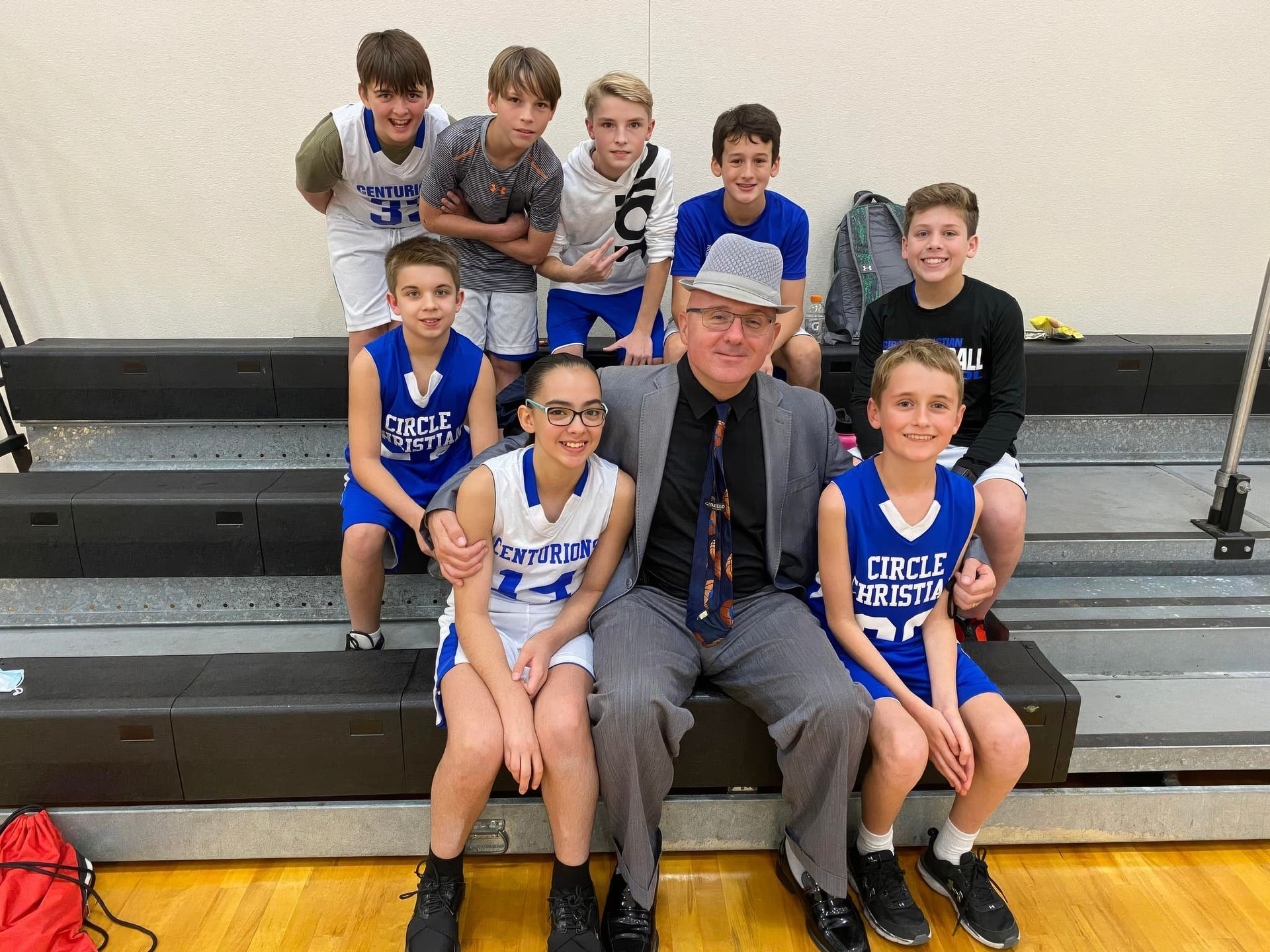 A man in a hat and glasses is hugging a little girl