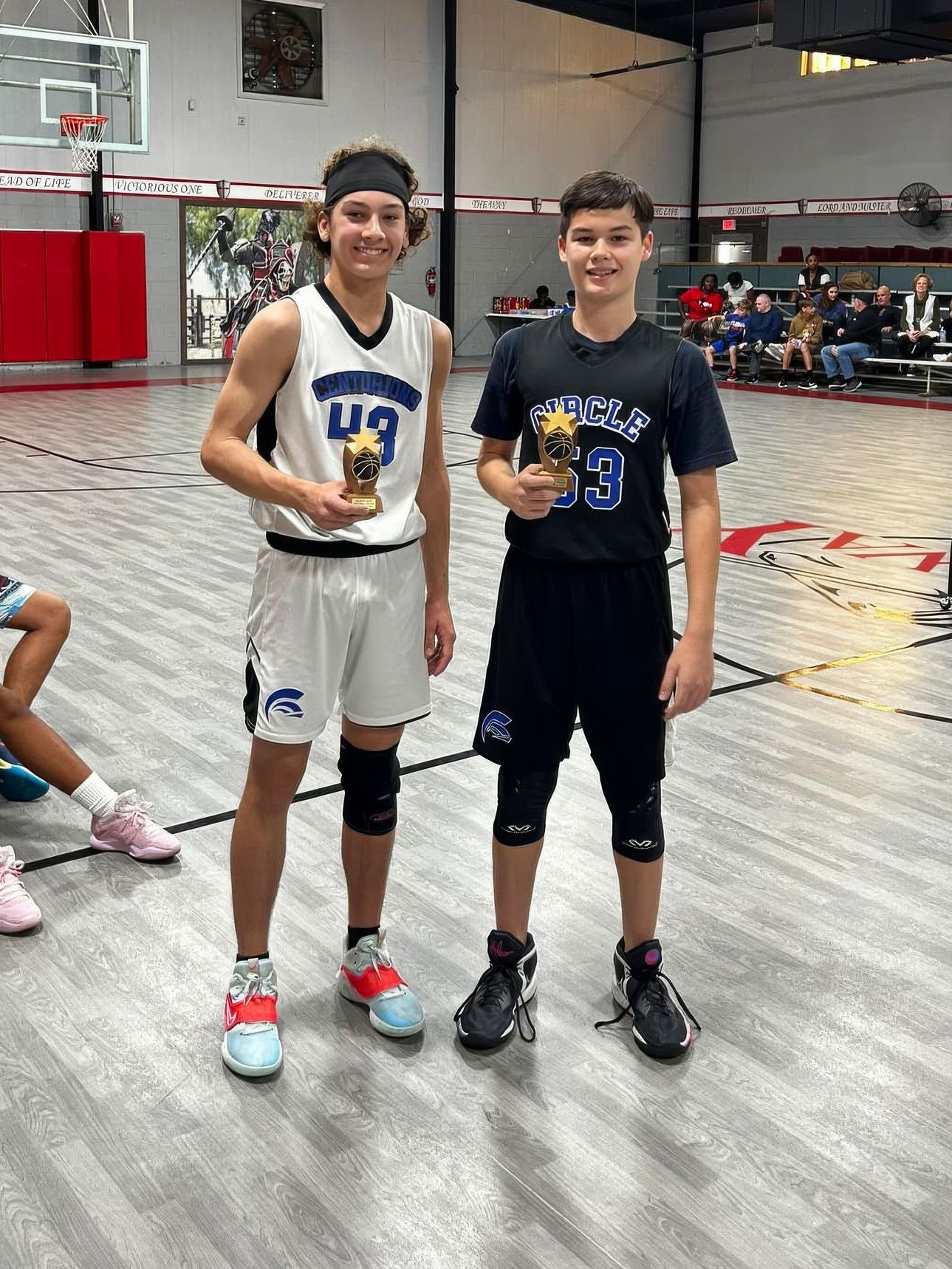 A group of basketball players are sitting on the court