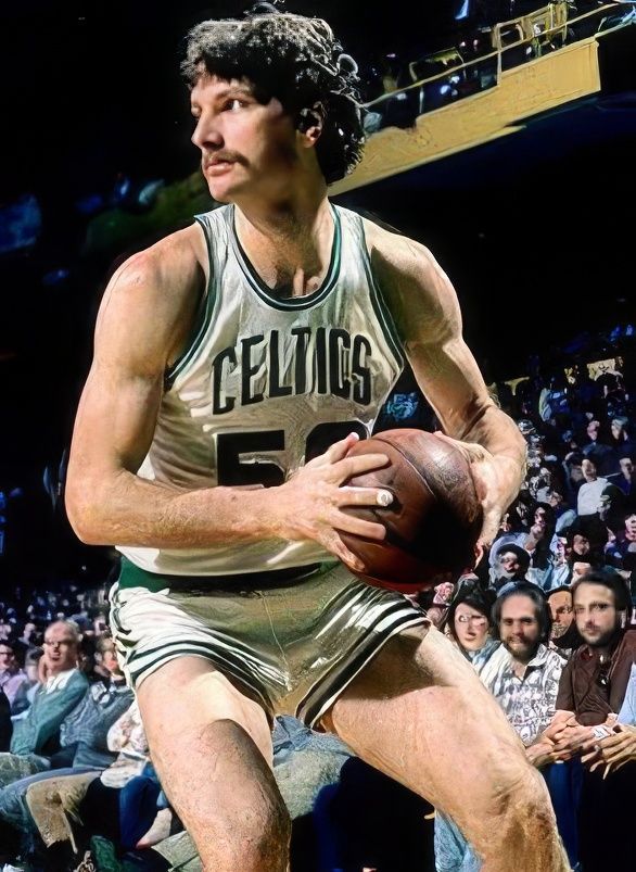 A man in a celtics jersey is holding a basketball