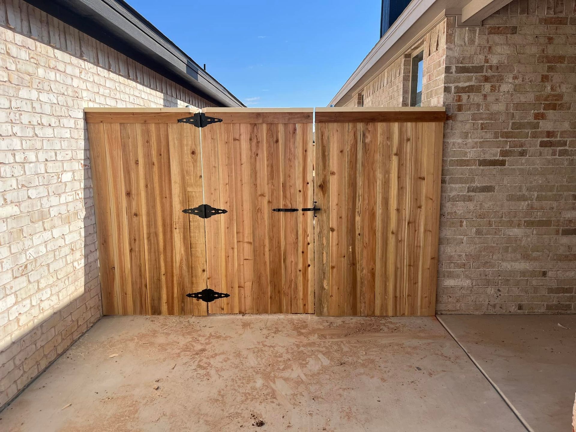 Wooden double gate between brick walls.