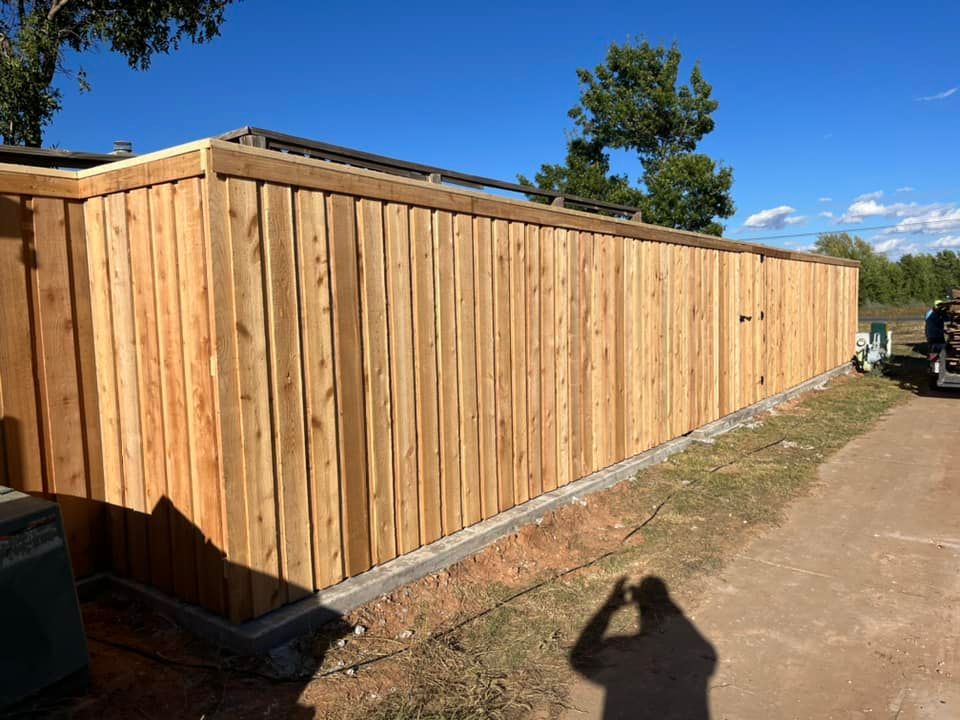 Wooden fence, newly constructed, in a sunny outdoor setting.